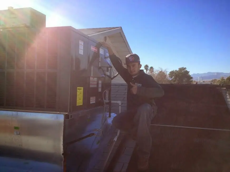 HVAC technician performing HVAC Inspection on a rooftop unit in Carlsbad